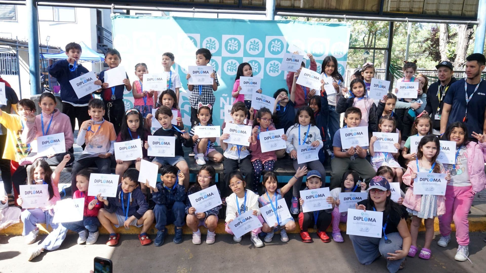 Niños y niñas con sus diplomas en la exhibición de talleres de natación